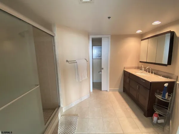 a spacious bathroom with a double vanity sink a large mirror and shower