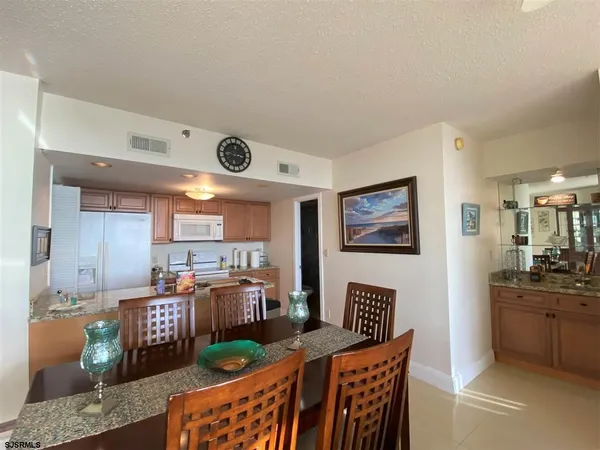 a kitchen with stainless steel appliances granite countertop a stove a sink a dining table and chairs