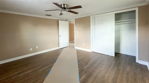 an empty room with windows and fan