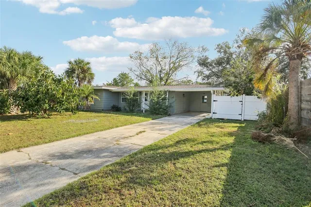a view of a house with a yard and potted plants