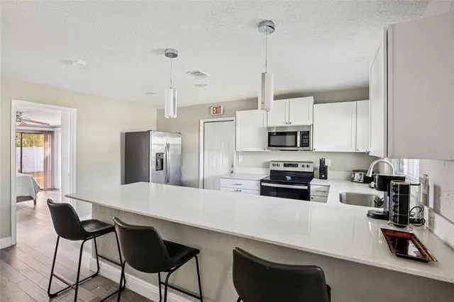 a bedroom with a large bed and a flat tv screen on dresser