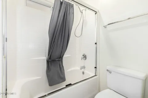 a bathroom with a shower a toilet and a window