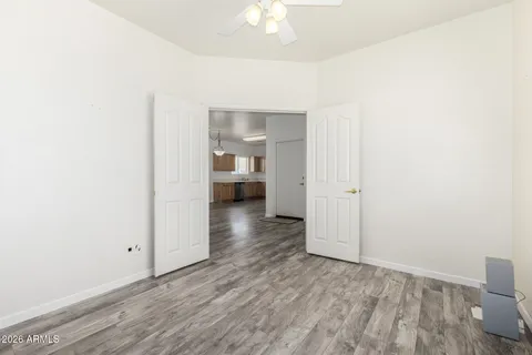 a view of a room with wooden floor and a ceiling fan