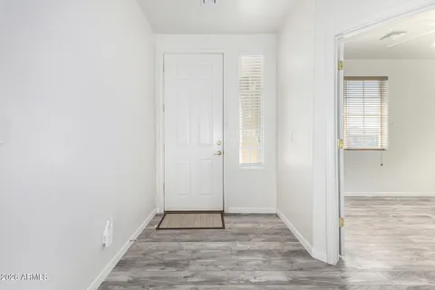 an empty room with wooden floor and mirror