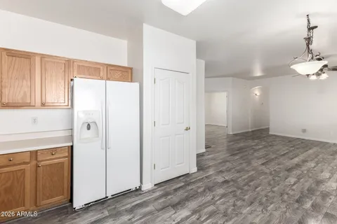 a view of a refrigerator in kitchen and white cabinets