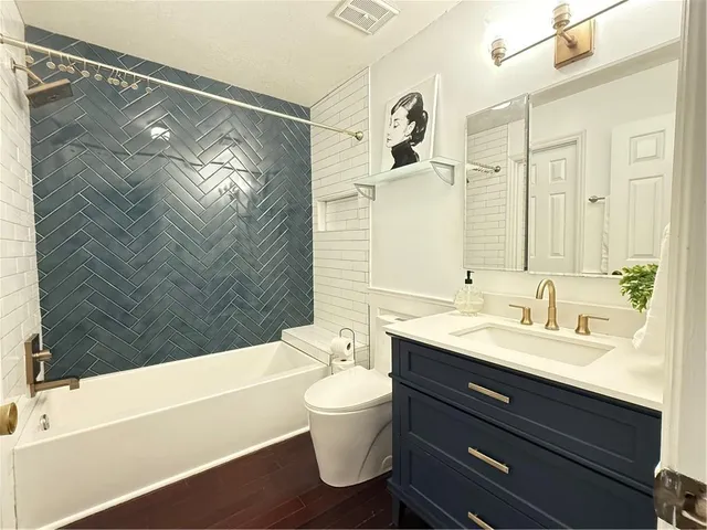a bathroom with a double vanity sink toilet mirror and bathtub