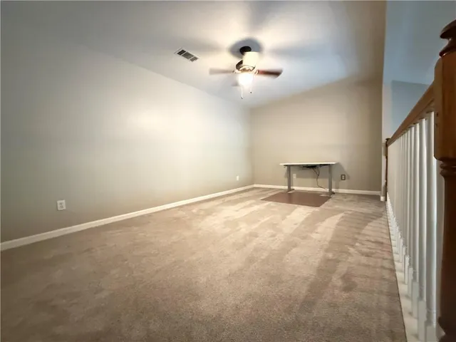 a view of staircase with railing and white walls