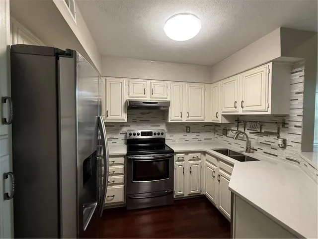 a kitchen with a refrigerator stove and sink