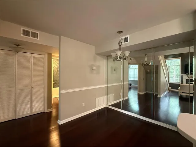 a view of a hallway with wooden floor and glass door