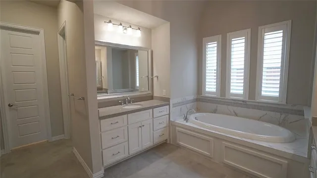a bathroom with a bathtub a double vanity sink a and a window