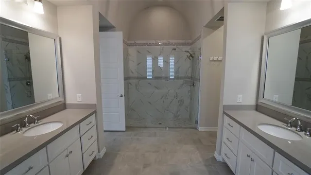 a bathroom with a double vanity sink mirror double and shower