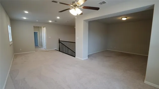 en empty room with windows and fan