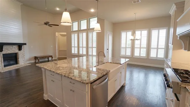 a kitchen with granite countertop a sink and wooden floor