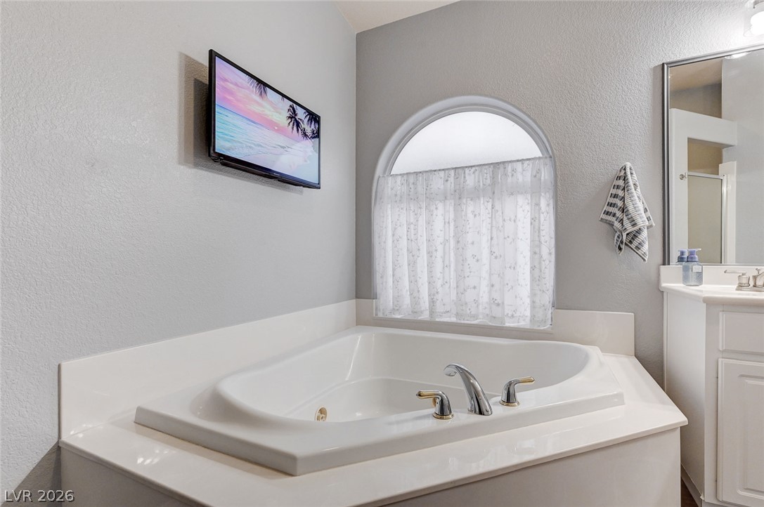1604 Cattle Ranch Place Henderson, NV 89002 - Photo 40 of 99 Indulge in a tranquil soak within this well-appointed bathroom featuring a built-in tub.