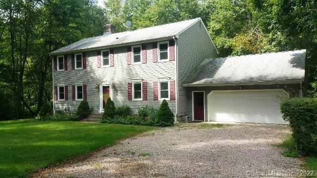 a front view of a house with a garden and yard