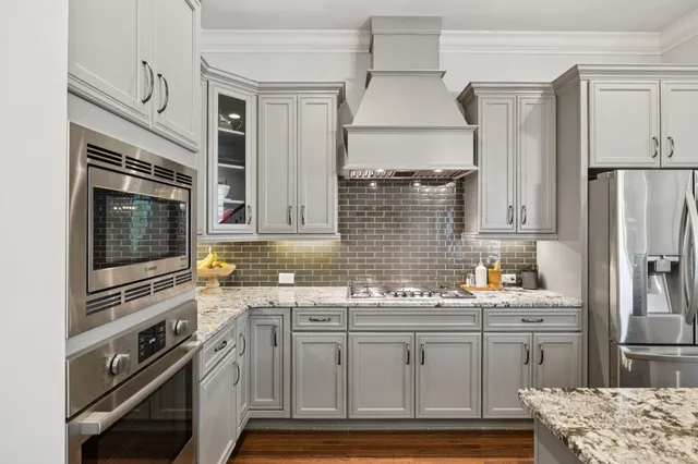 a kitchen with stainless steel appliances granite countertop a refrigerator and a sink