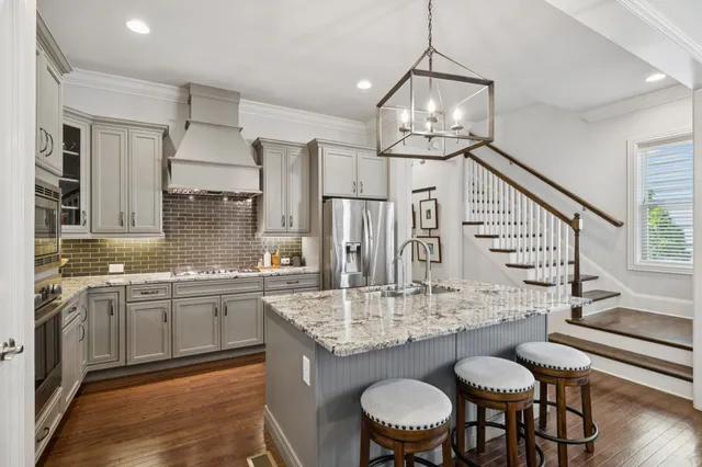 a kitchen with stainless steel appliances granite countertop a sink refrigerator and microwave