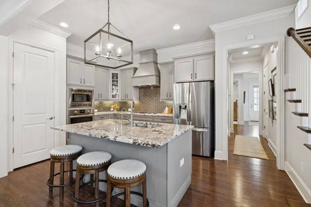a living room with furniture a flat screen tv and kitchen view