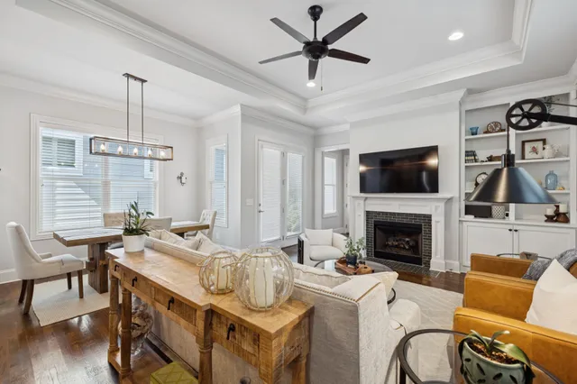 a living room with furniture kitchen view and a wooden floor
