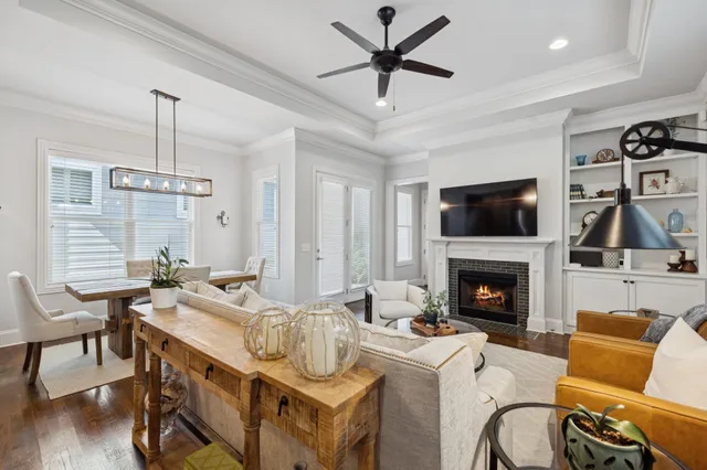 a living room with furniture ceiling fan and a wooden floor