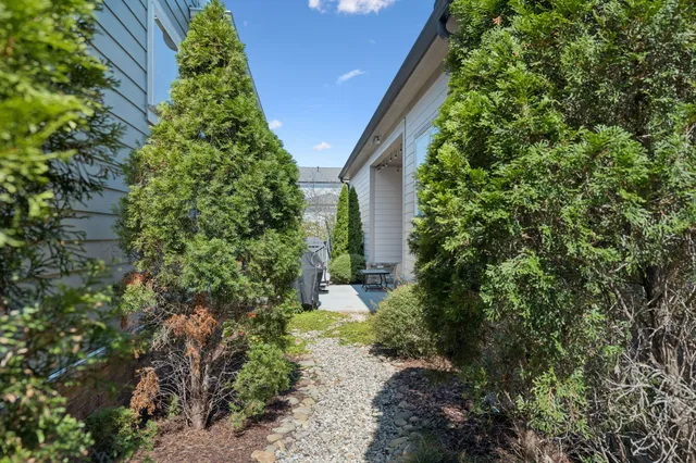 a view of a patio with couches and table and chairs with wooden fence and plants
