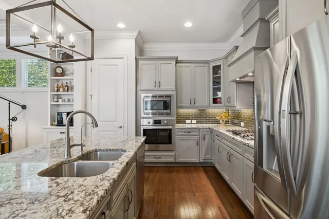 a kitchen with stainless steel appliances white cabinets and a sink