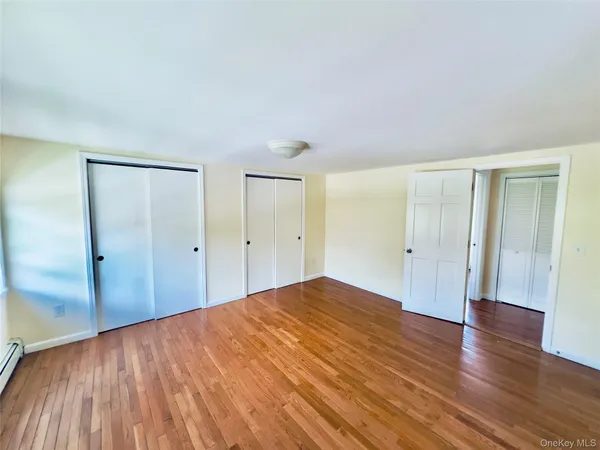 a big room with wooden floor and bathroom view