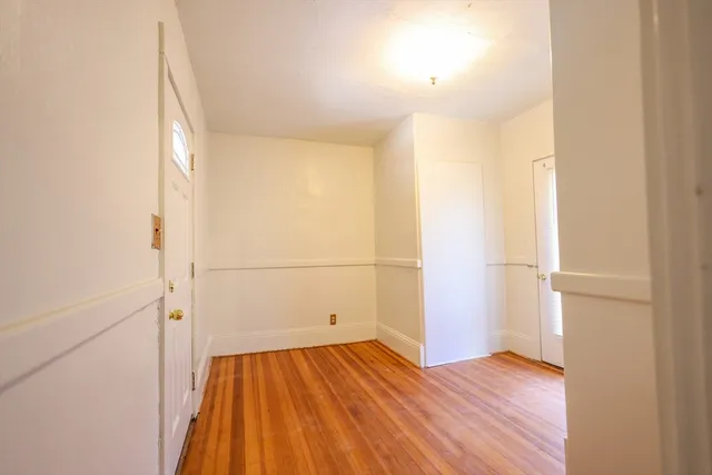 an empty room with wooden floor and white walls