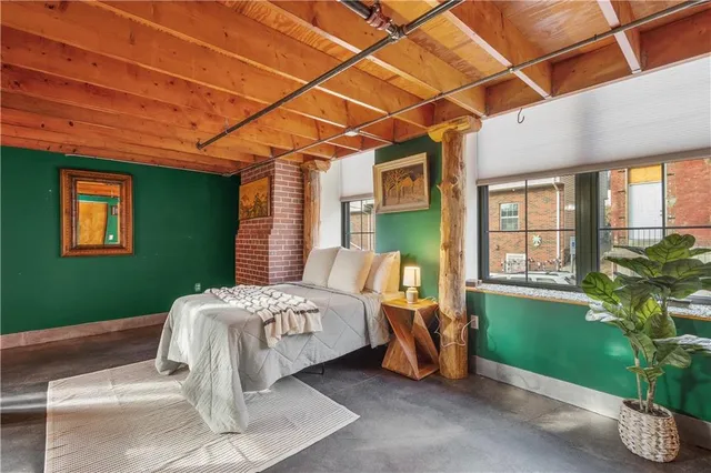 a bed sitting in a spacious bedroom next to a window