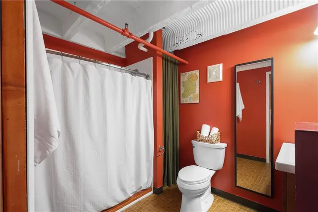 a bathroom with a toilet and a shower curtain