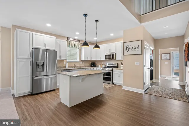 a kitchen with stainless steel appliances granite countertop a refrigerator sink and stove