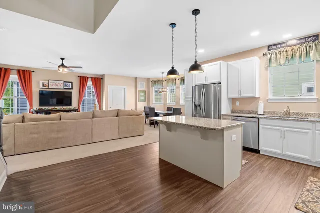 a living room with furniture a dining table and a chandelier