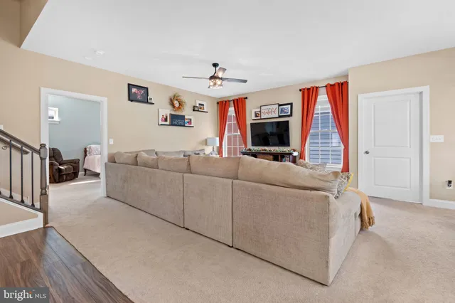 a bedroom with a bed a flat tv screen and a dresser