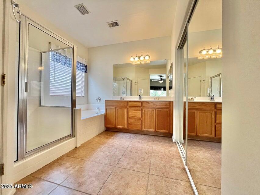 16908 West Northampton Road Surprise, AZ 85374 - Photo 10 of 13 a large bathroom with a large mirror vanity and shower
