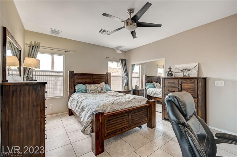 987 Cutter Street Henderson, NV 89011 - Photo 9 of 17 Ceramic tile flooring spans this generously sized primary bedroom, equipped with ample natural light.