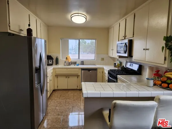 a kitchen with a table chairs refrigerator and cabinets