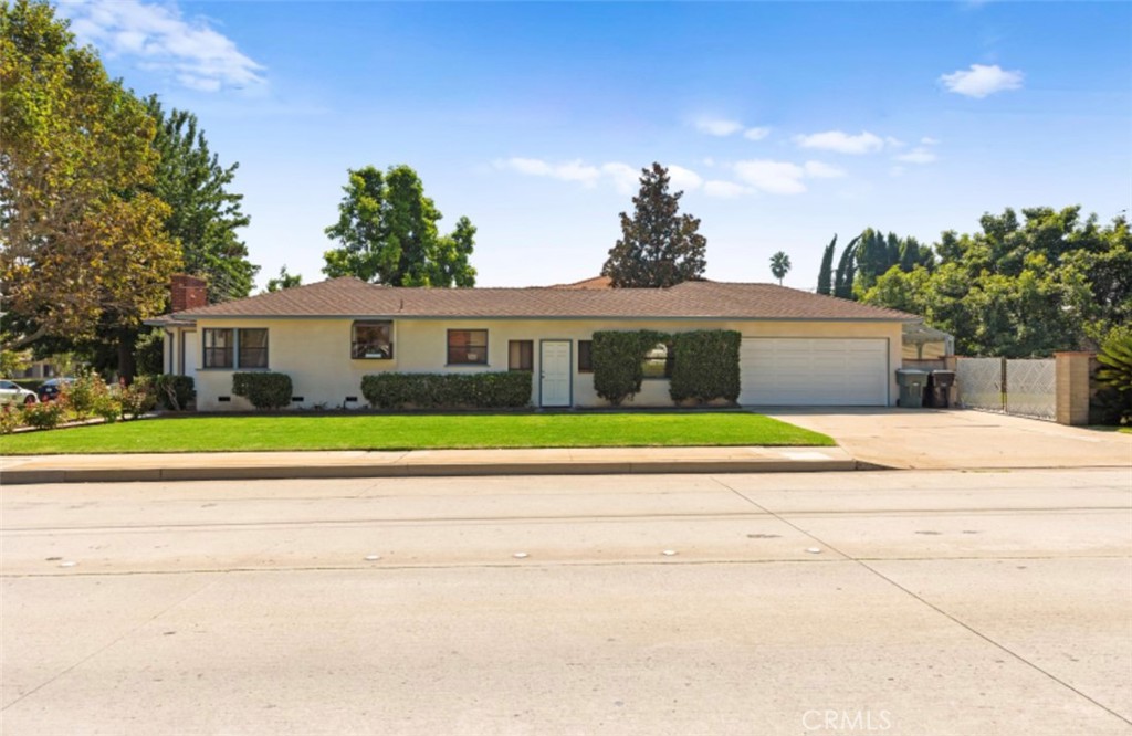 a front view of a house with a yard and potted plants