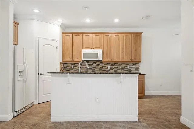 a kitchen with granite countertop white cabinets and stainless steel appliances
