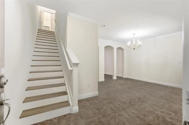 a view of a hallway with stairs and wooden floor