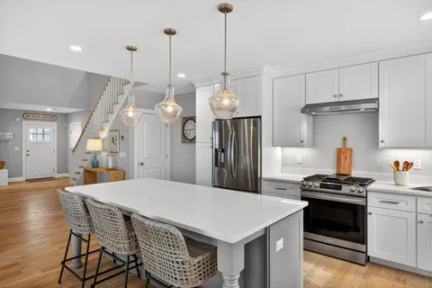 a kitchen that has a stove a table and chairs in it