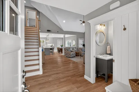 a view of a hallway with living room and wooden floor