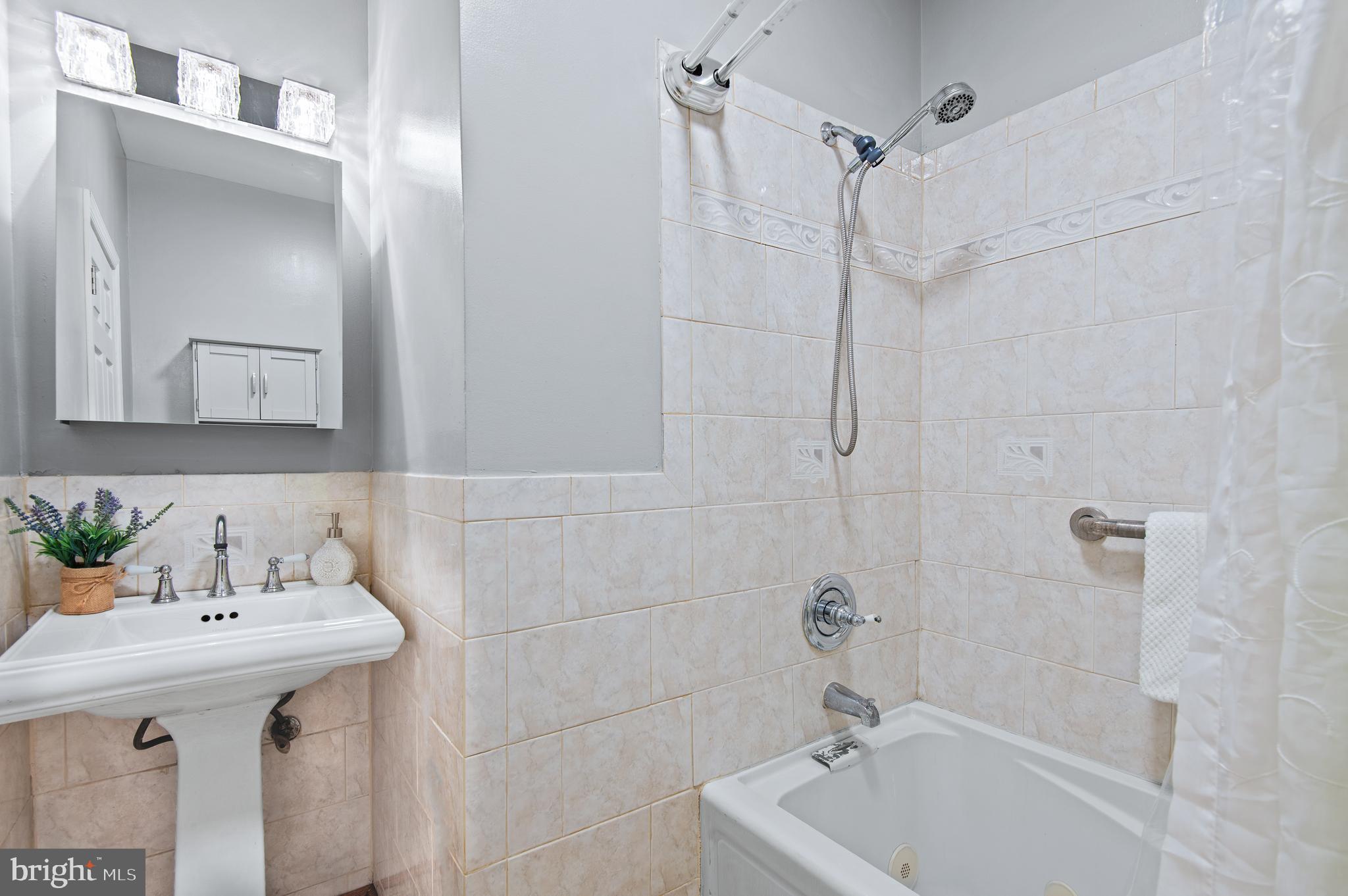 1236 Sargeant Street Baltimore, MD 21223 - Photo 14 of 19 a bathroom with a sink a mirror and a bathtub