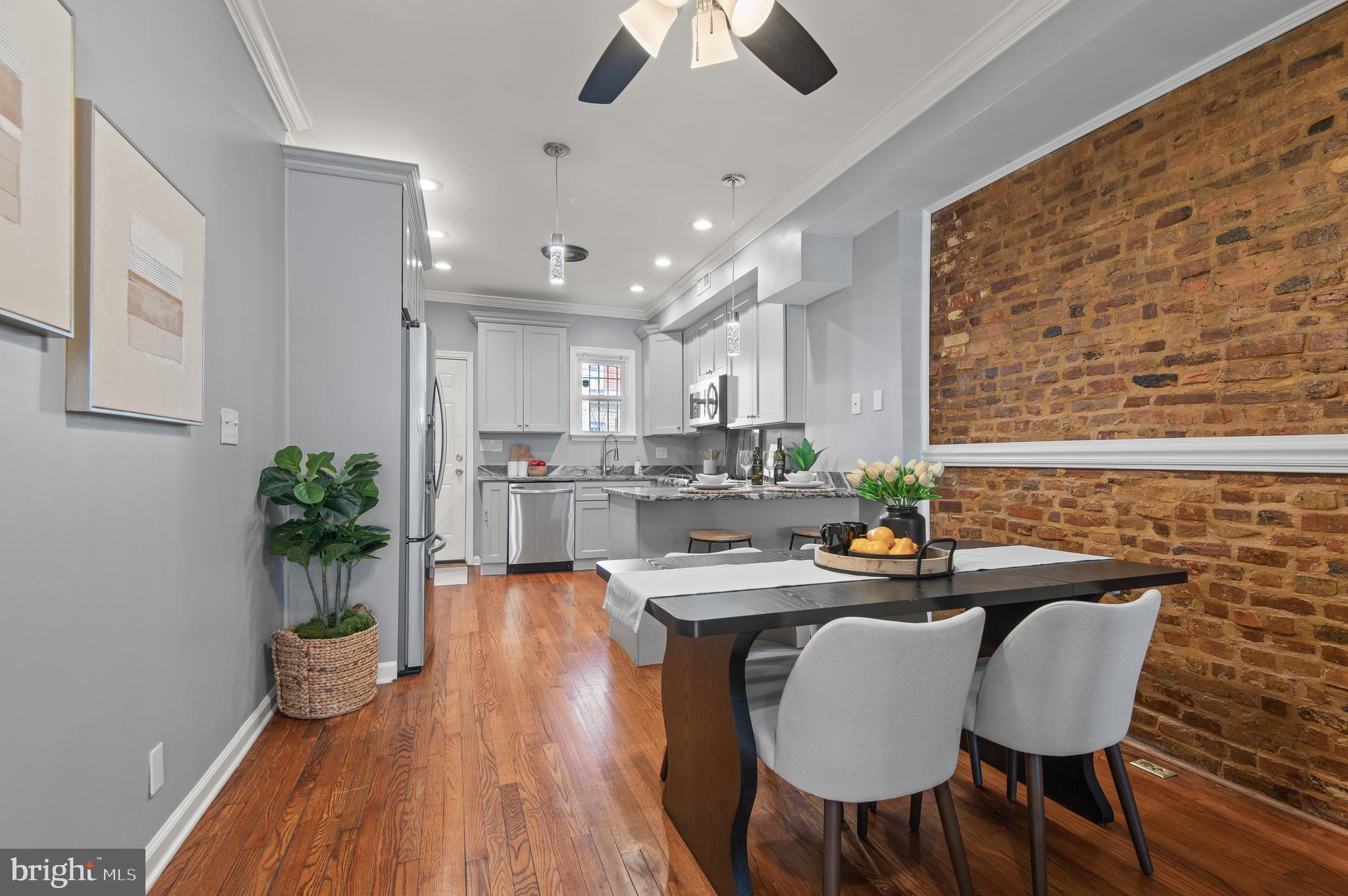 1236 Sargeant Street Baltimore, MD 21223 - Photo 4 of 19 a kitchen with granite countertop white cabinets stainless steel appliances and dining table