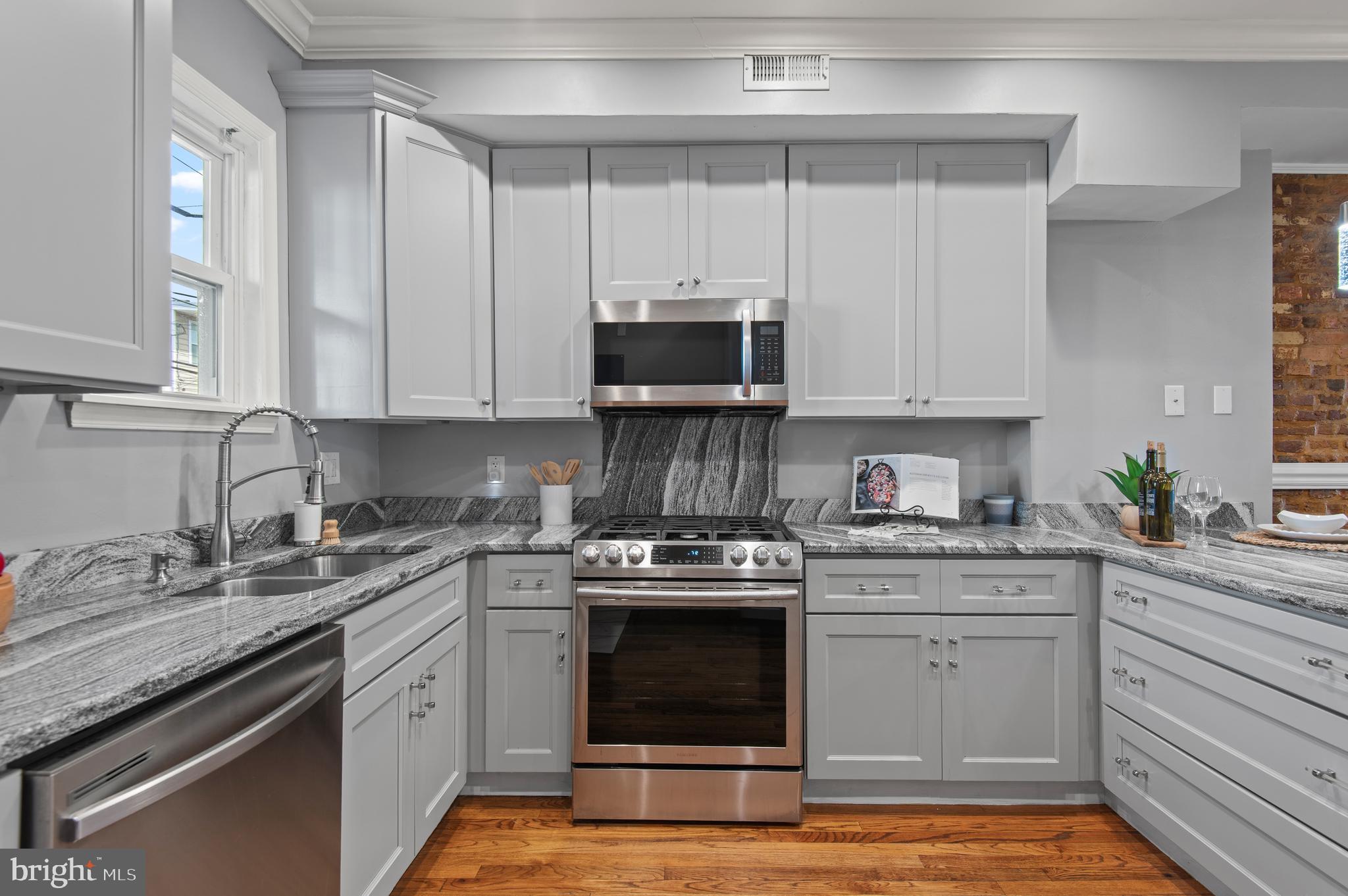 1236 Sargeant Street Baltimore, MD 21223 - Photo 7 of 19 a kitchen with granite countertop a stove sink and cabinets