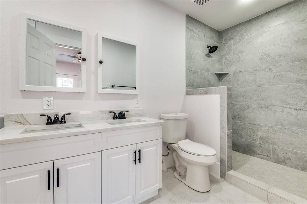 2502 West Lovers Lane Dallas, TX 75235 - Photo 14 of 20 a bathroom with a sink a toilet and a mirror