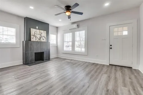 an empty room with windows and a fireplace