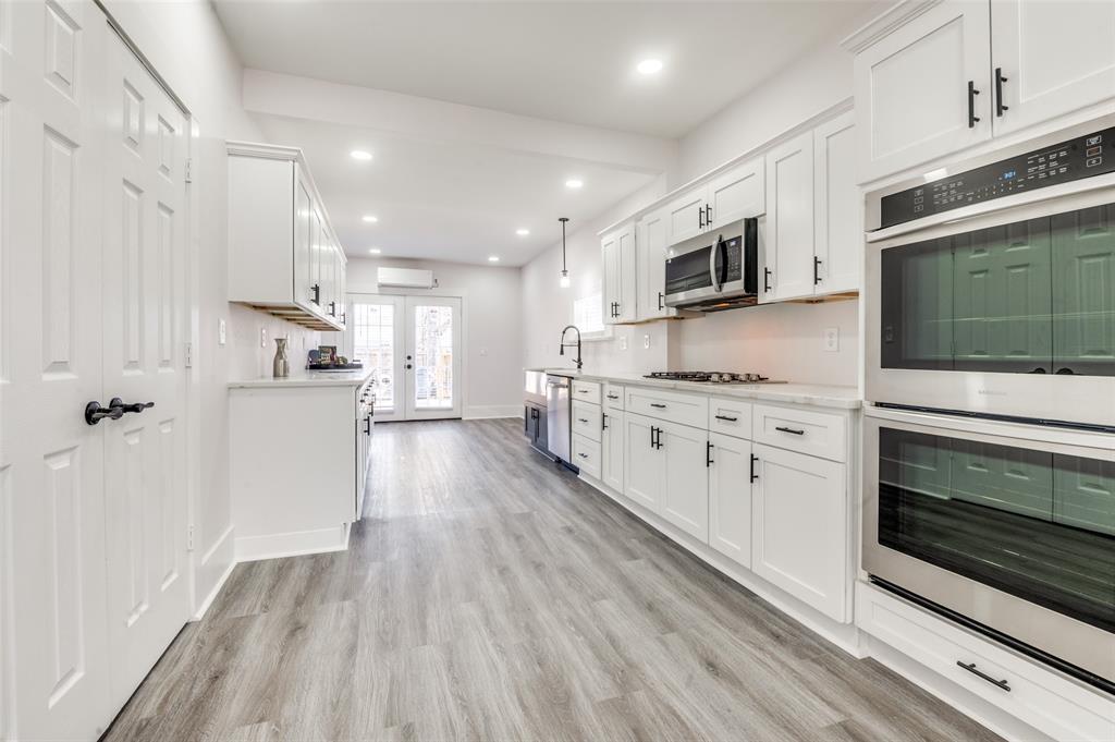 2502 West Lovers Lane Dallas, TX 75235 - Photo 6 of 20 a kitchen with stainless steel appliances kitchen island granite countertop a stove a sink and a microwave