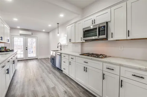 a kitchen with stainless steel appliances granite countertop a stove a sink and a microwave