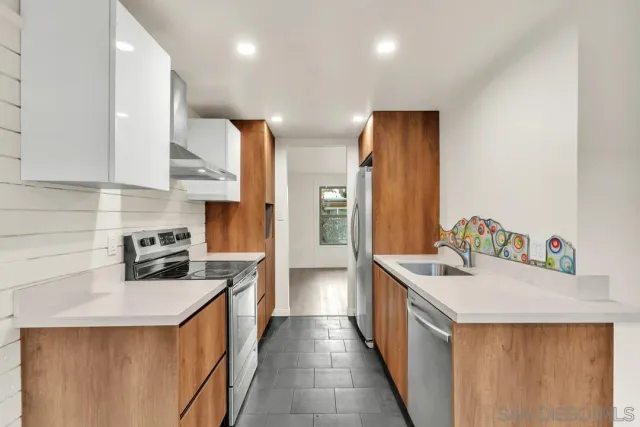 a kitchen with a sink stove top oven and cabinets