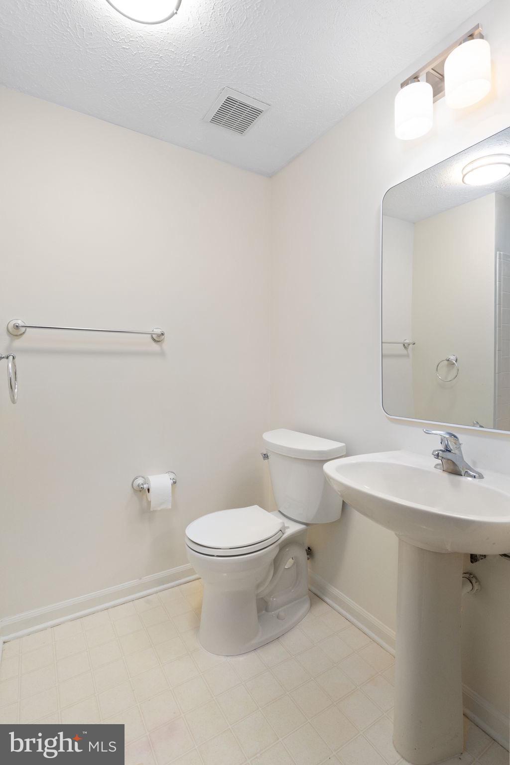 1404 Golden Rod Court, Unit B Belcamp, MD 21017 - Photo 20 of 25 a white toilet sitting next to a bathroom sink